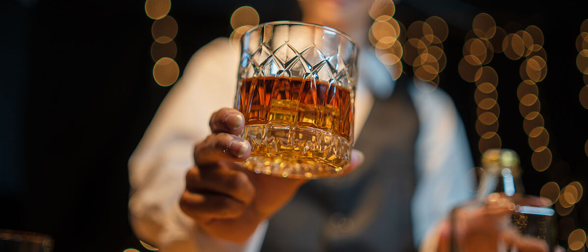 Barkeeperin reicht Glas