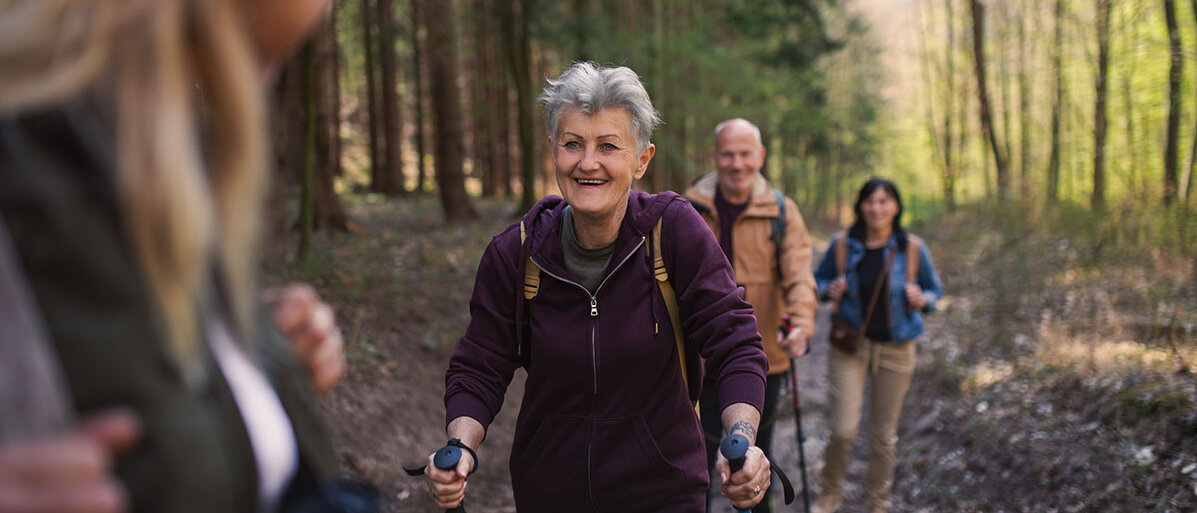 Gesunder Lebensstil Gruppe von Senior*innen beim Wandern im Wald