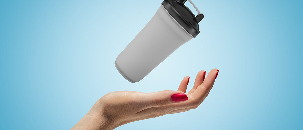 Nahaufnahme einer Hand, die einen Shaker in der Hand nach oben wirft