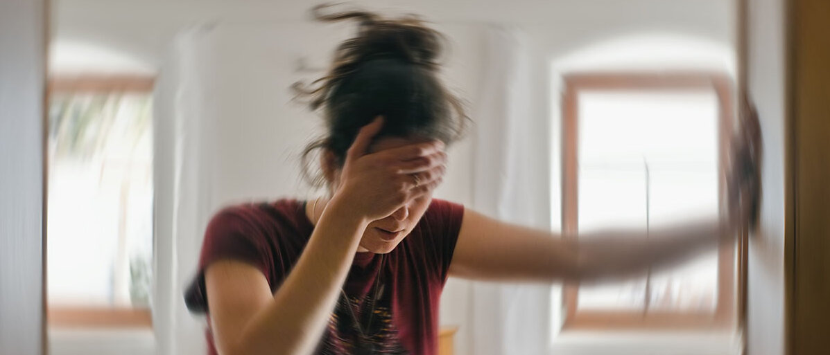 Schlaganfall bei Frauen Frau mit Schwindel greift sich an den Kopf