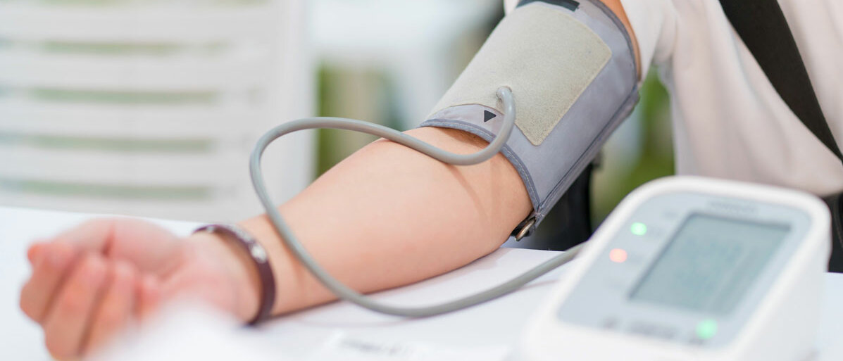 Frau bekommt von Arzt Blutdruck gemessen