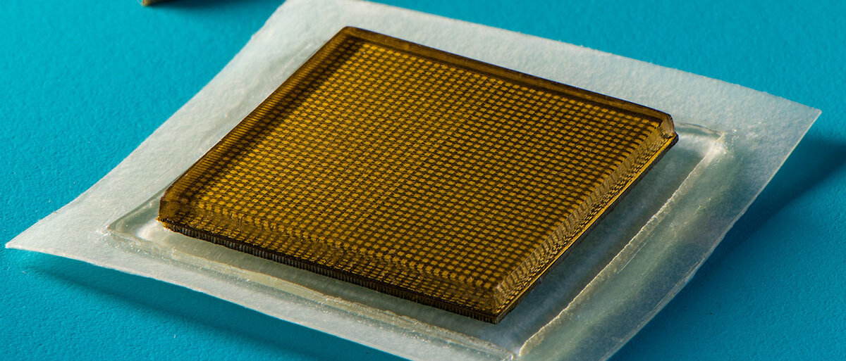 Ein Foto des Ultraschallpflasters: In ein transparentes, braunes Quadrat ist die Elektronik eingebettet.