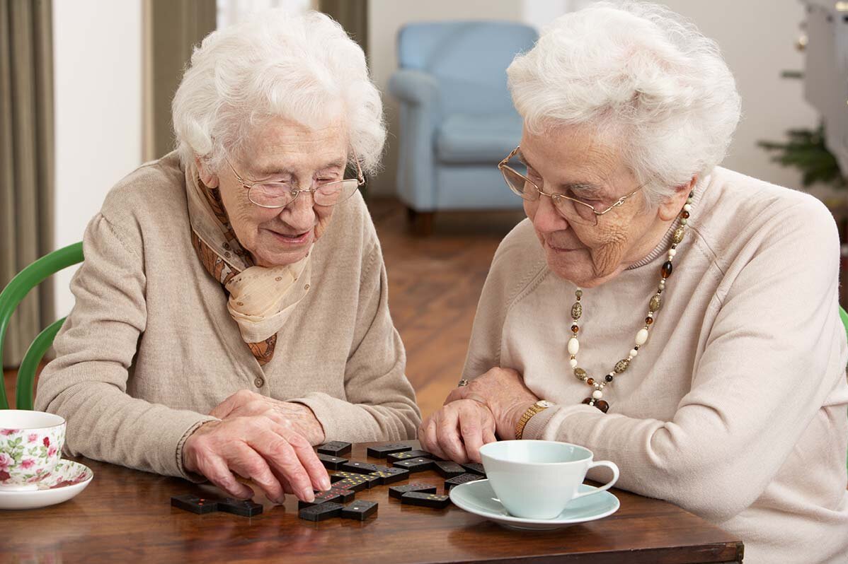 Seniorinnen spielen Domino.