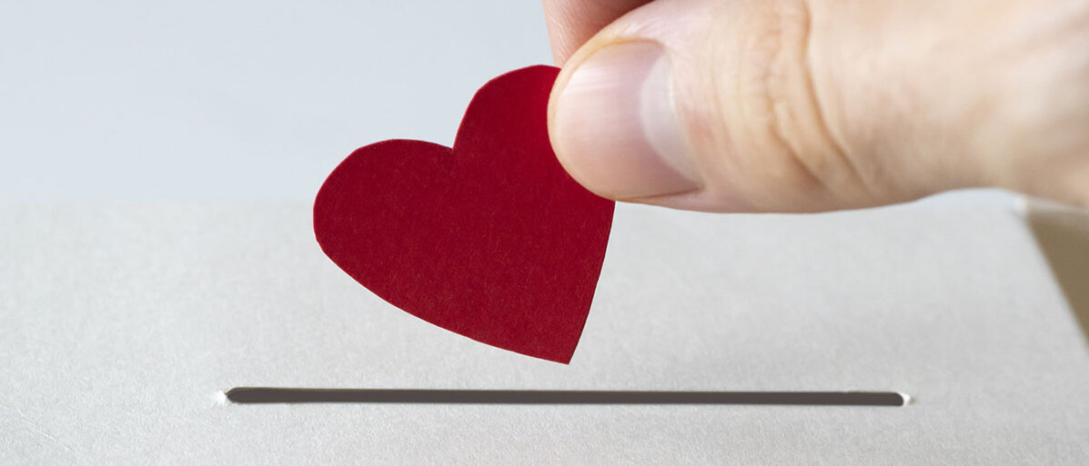 Papier-Herz wandert in Sparschlitz 