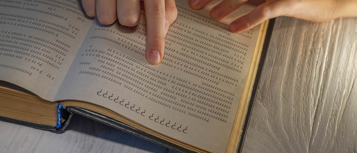 Ein Kind liest ein Buch und folgt den Buchstaben und Zeilen mit dem Finger. Aber alle Buchstaben sind Fragezeichen.