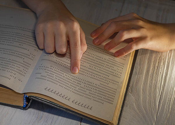 Ein Kind liest ein Buch und folgt den Buchstaben und Zeilen mit dem Finger. Aber alle Buchstaben sind Fragezeichen.