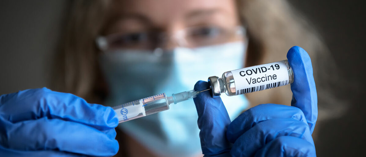 Ärztin zieht Spritze für Corona Impfung auf