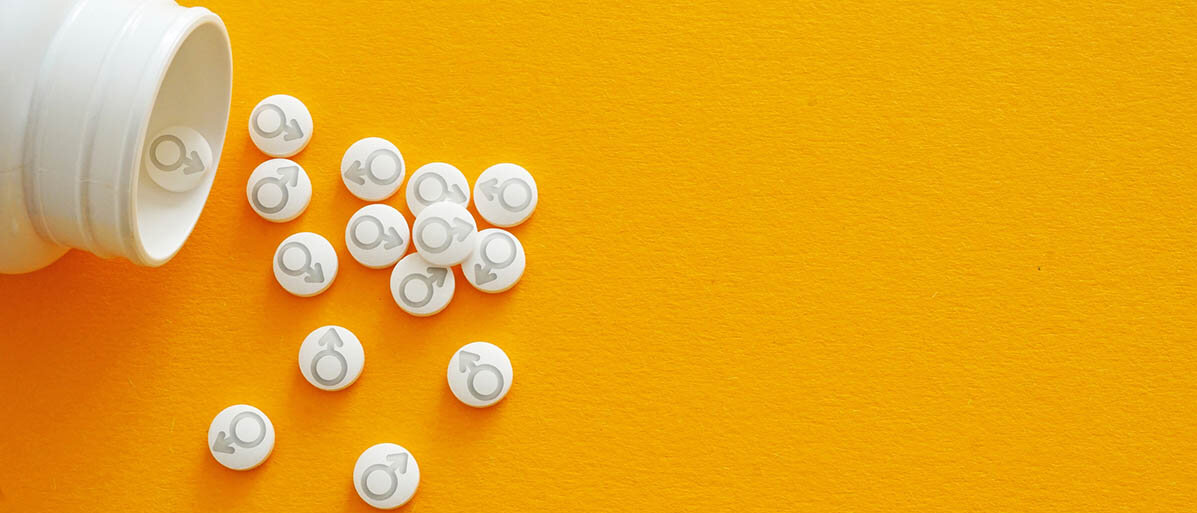 Testosteron-Ersatztherapie hilft nicht bei sexueller Dysfunktion, es steigert nicht die Potenz. Eine offene Tablettendose, aus der Tabletten herauskullern: Sie sind mit dem Männlichkeitssymbol geprägt (Kriegsgott Mars, Kreis und Pfeil).