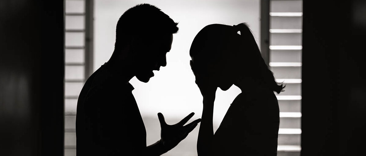 Konflikte in der Partnerschaft entstehen zum Beispiel durch unterschiedliche Bedürfnisse, etwa beim Kinderwunsch. Steht die Beziehung vor der Trennung oder ist ein Kompromiss möglich? Silhouetten im Gegenlicht: Ein Paar Streitet. Sie hält das Gesicht in Händen, er gestikuliert.