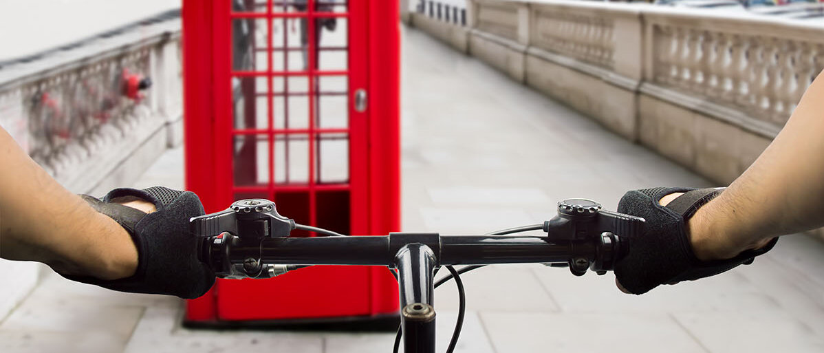 Aus Fahrrad Sicht auf eine rote Telefonzelle