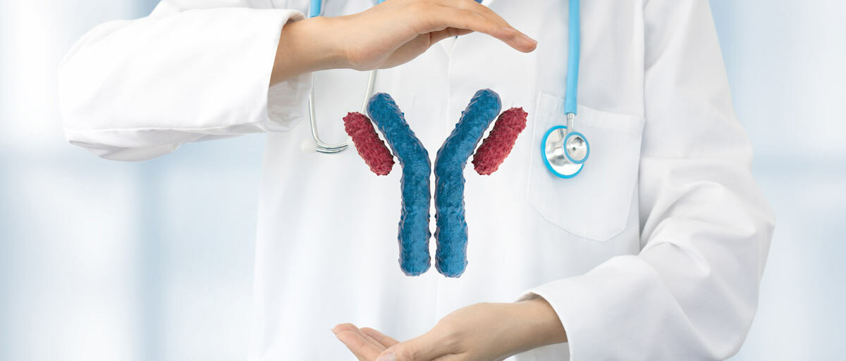 Eine Person in weißem Kittel präsentiert vor ihrem Oberkörper zwischen den Händen ein schwebendes Modell eines Y-förmigen Antikörpers.