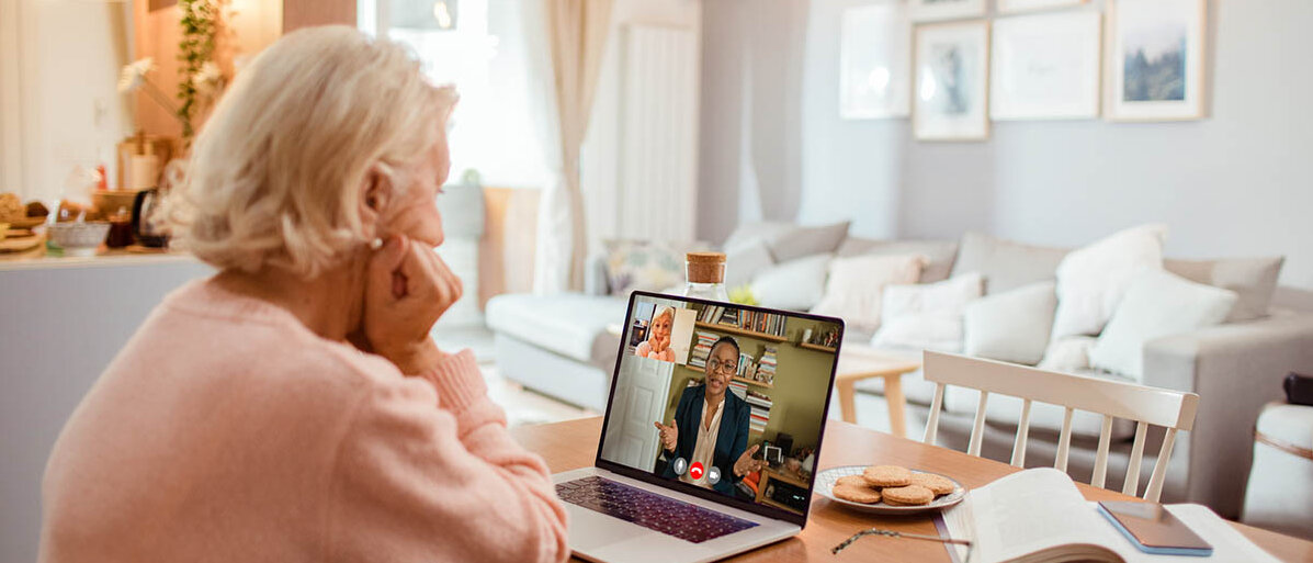 Assistierte Telemedizin: Die Videosprechstunde in der Apotheke soll technisch wenig versierten Menschen Zugang zu Videosprechstunden – und E-Rezepten – sichern. Eine Seniorin sitzt am Küchentisch und ist im Videocall mit ihrer Ärztin.