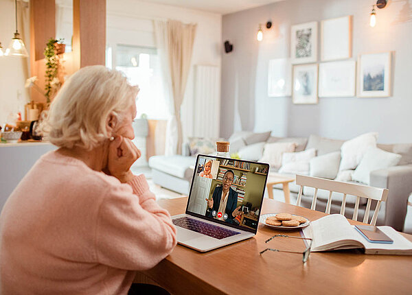 Assistierte Telemedizin: Die Videosprechstunde in der Apotheke soll technisch wenig versierten Menschen Zugang zu Videosprechstunden – und E-Rezepten – sichern. Eine Seniorin sitzt am Küchentisch und ist im Videocall mit ihrer Ärztin.