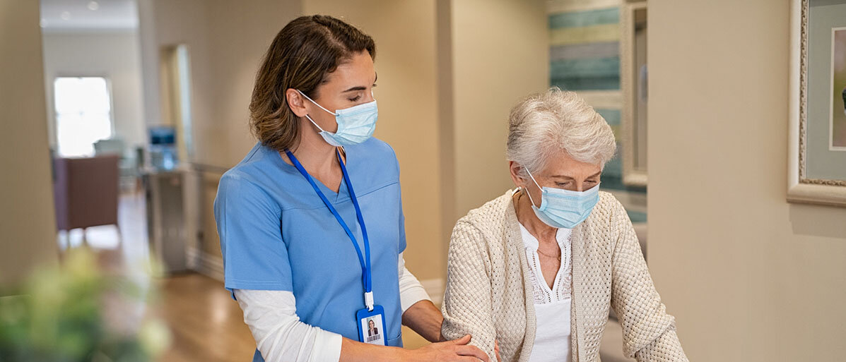 Krankenschwester hilft Seniorin im Altersheim