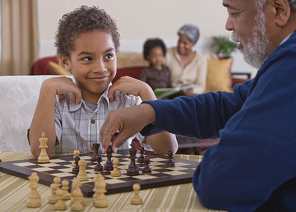 Gehirnentwicklung in fünf Phasen: So funktioniert die Entwicklung vom Gehirn Opa und Enkel spielen Schach.