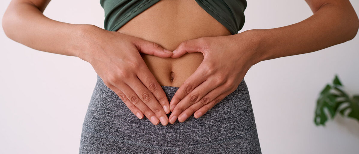 Darmmikrobiom & Heuschnupfen Hände einer Frau zu einem Herz geformt auf ihrem Bauch