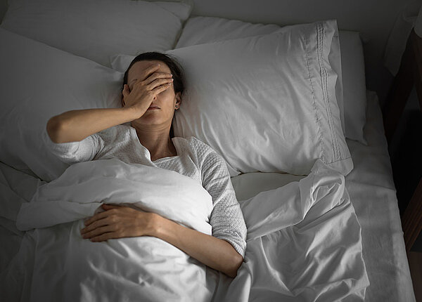 Frau im Bett, die offensichtlich nicht schlafen kann