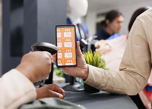Coupon-Marken auf einem Smartphone werden an der Kasse abgescannt