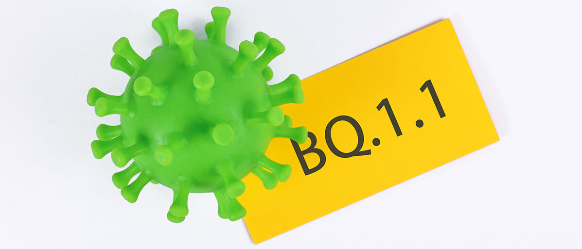 Corona Virus in grün und nebenan ein gelbes Schild mit BQ 1.1.
