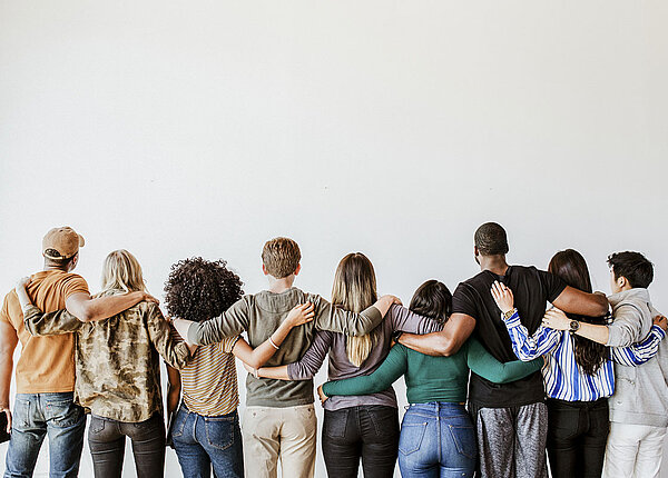 Rückenansicht von verschiedenen Menschen, die sich umarmen