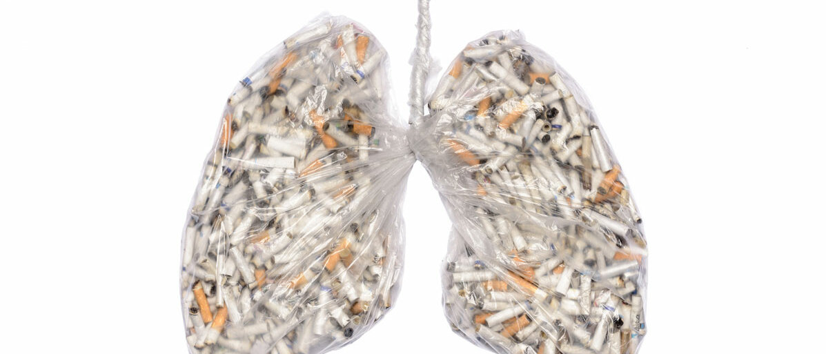 Eine Mülltüte in Lungenform enthält unzählige Zigarettenstummel.