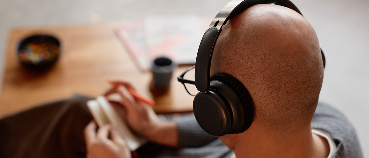 Over-Ear-Kopfhörer Glatzköpfiger Mann, der Musik über Kopfhörer hört
