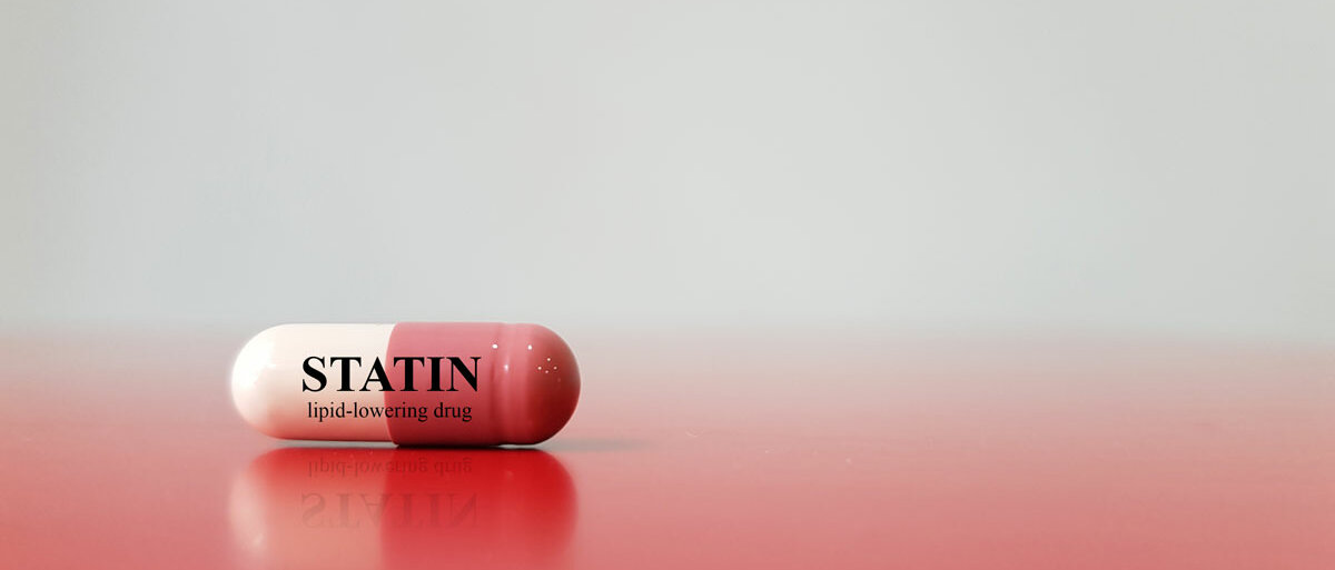 Eine rot-weiße Kapsel trägt die Aufschrift "STATIN lipid-lowering-drug".