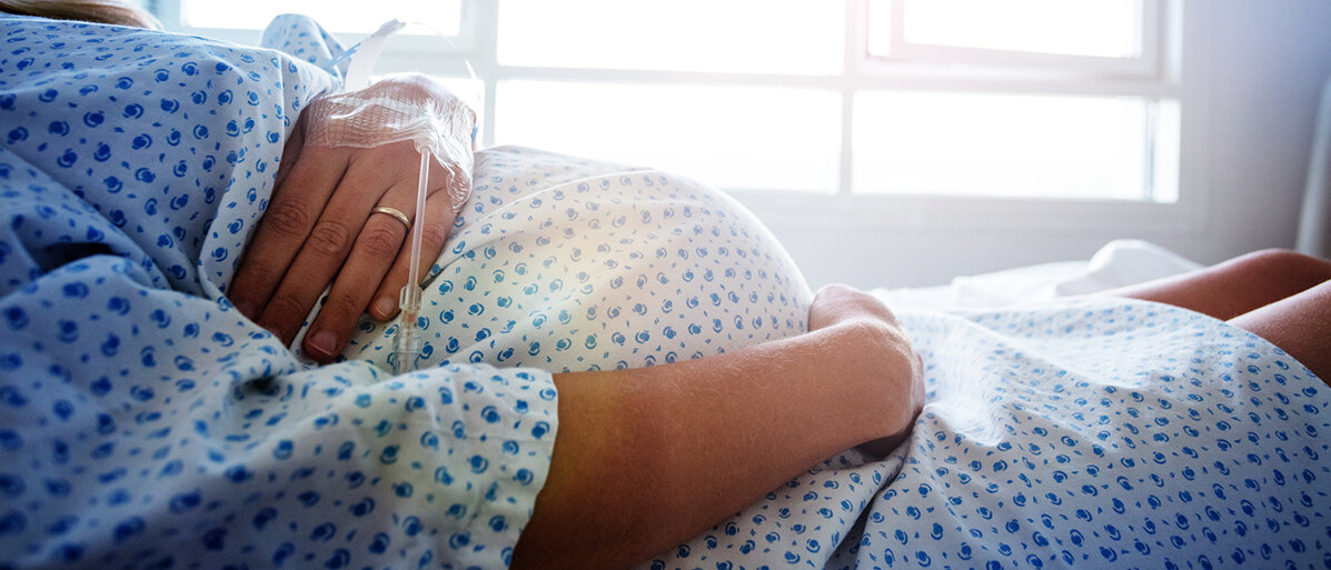 Eine schwangere Frau im Krankenhaus, Nahaufnahme vom Bauch