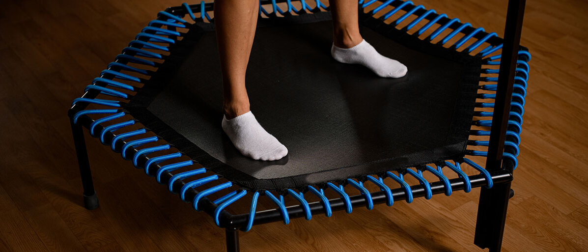 Nahaufnahme von weiblichen Beinen auf einem Mini-Trampolin