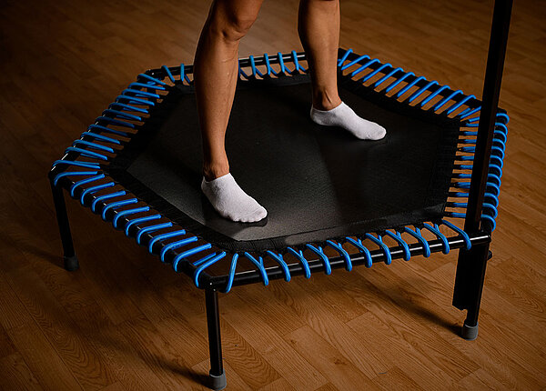 Gelenkschonendes Training mit dem Mini-Trampolin Nahaufnahme von weiblichen Beinen auf einem Mini-Trampolin