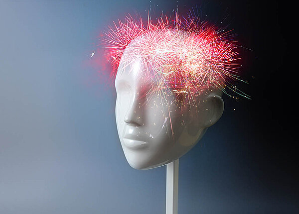 Dopamin ist ein Botenstoff im Gehirn. Modell eines Kopfes. Im Stirn- und Schädelbereich explodiert ein Feuerwerk.