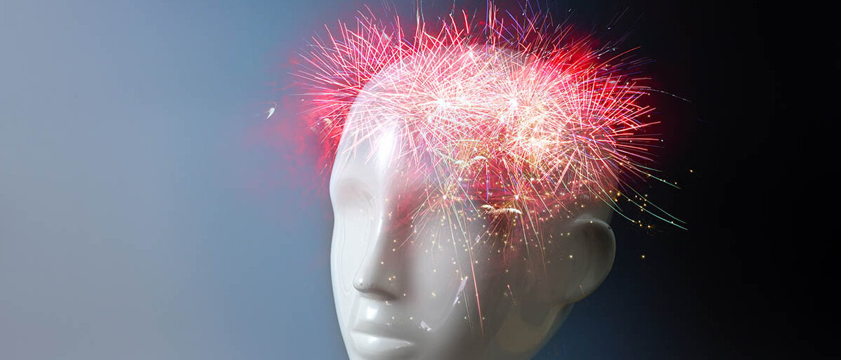 Dopamin ist ein Botenstoff im Gehirn. Modell eines Kopfes. Im Stirn- und Schädelbereich explodiert ein Feuerwerk.