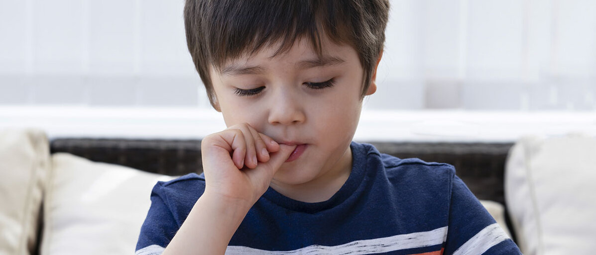 Nägelkauen bei Kindern erkennen und verstehen Kleiner Junge beißt auf seinen Fingernägeln