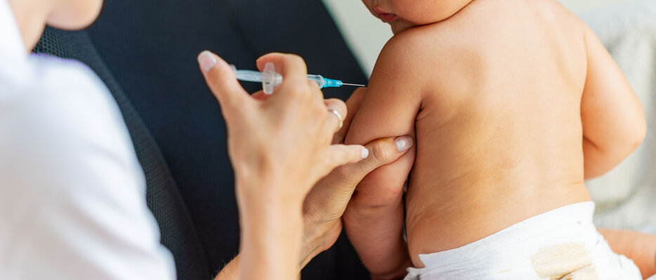 Baby bekommt eine Impfung in den linken Oberarm