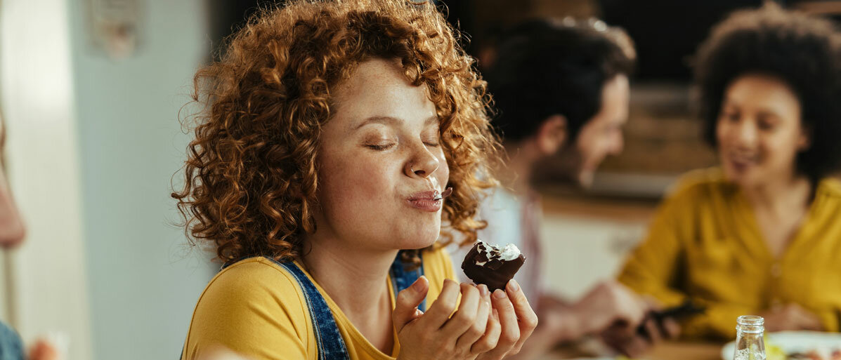 Frau isst etwas leckeres und genießt es