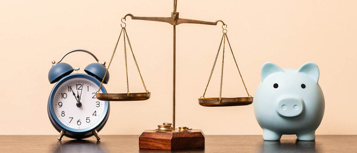 Eine Balkenwaage. Davor stehen auf der einen Seite ein Wecker, auf der anderen Seite ein Sparschwein.