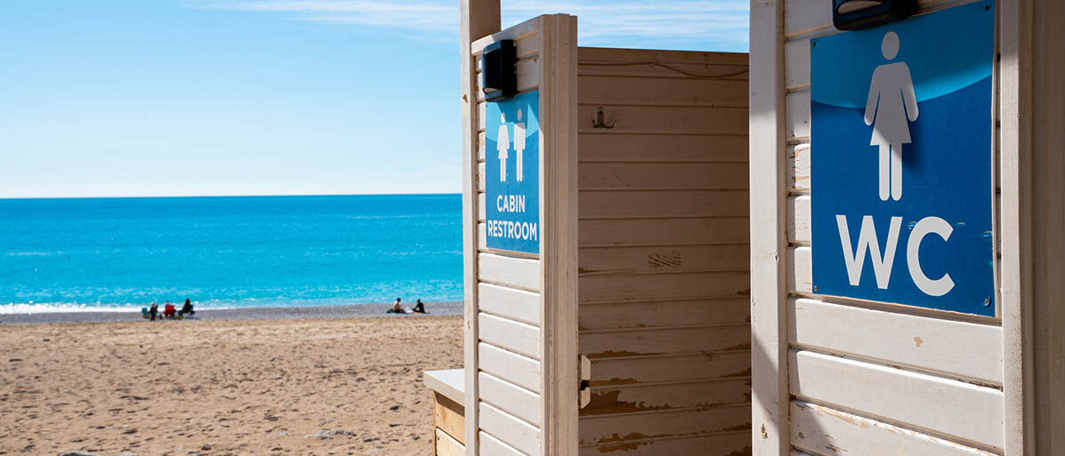Reisedurchfall vorbeugen mit Probiotika vor der Reise und welche Medikamente helfen, wenn es doch zu Durchfall im Urlaub kommt Eingang eines Toilettenhäuschens am Strand