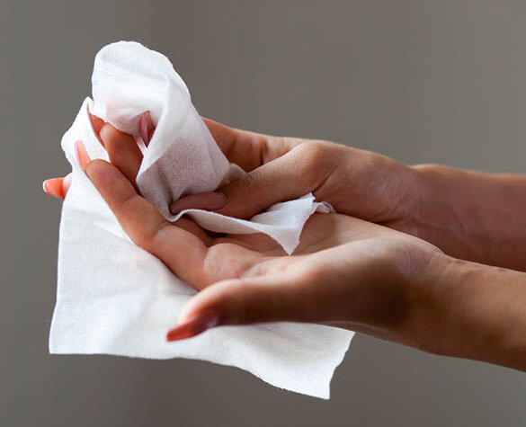 Eine Frau wischt sich die Hände mit einem Feuchttuch ab.