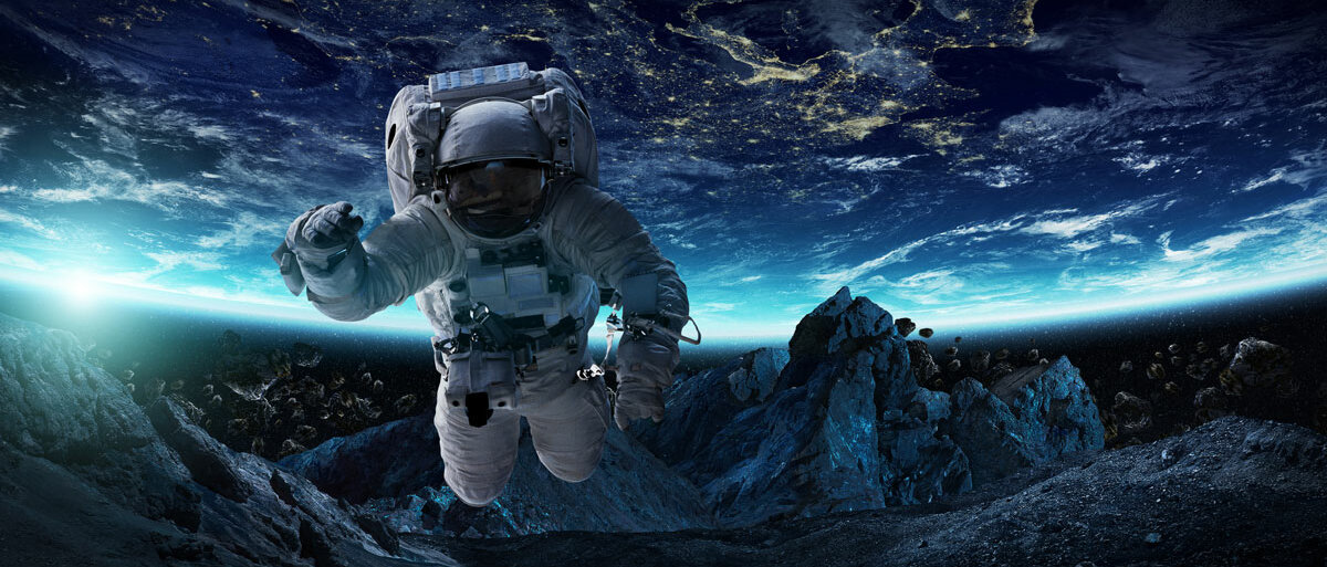Ein Astronaut im Raumanzug schwebt über einen steinigen Himmelskörper. Im Hintergrund über Kopf sieht man einen bewohnten Planeten.