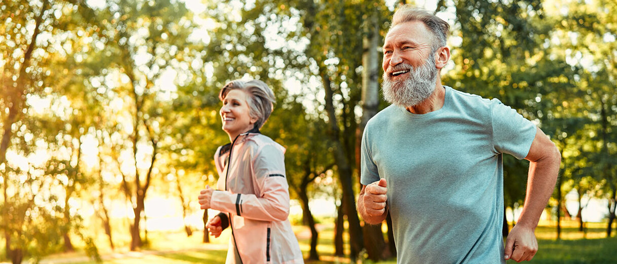 Sport und Herzgesundheit Älteres Paar joggt gemeinsam durch einen Park