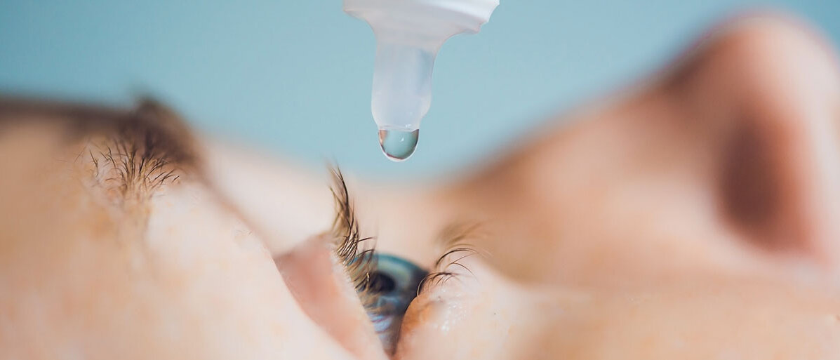 Kind bekommt Augentropfen verabreicht