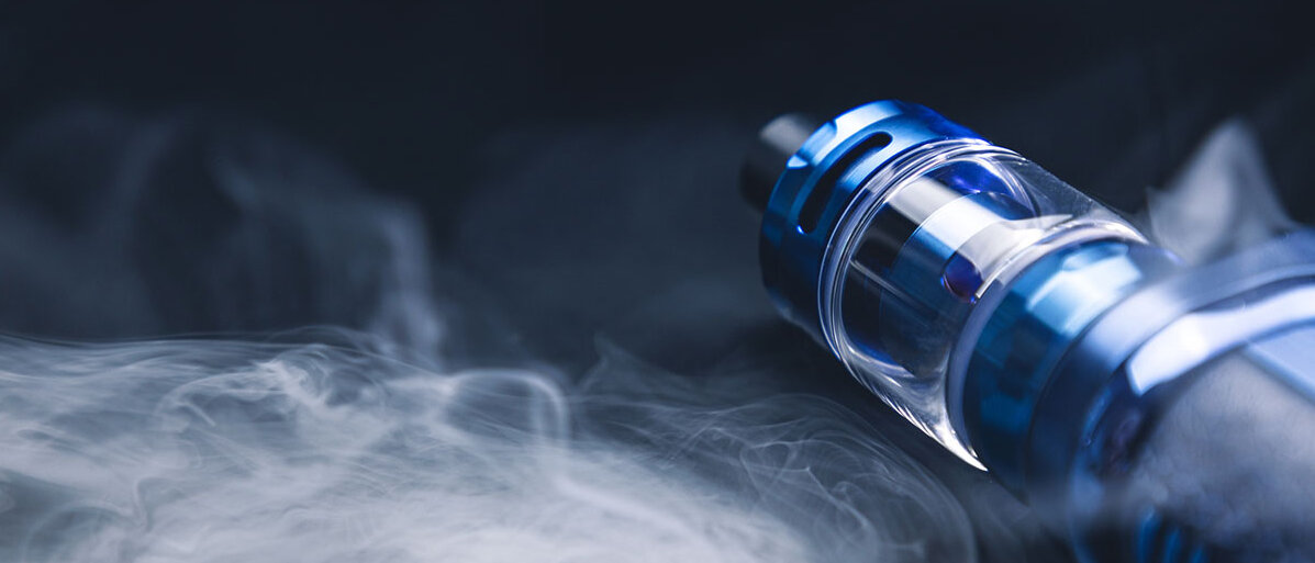 Eine E-Zigarette liegend und drum herum ist jede Menge Rauch