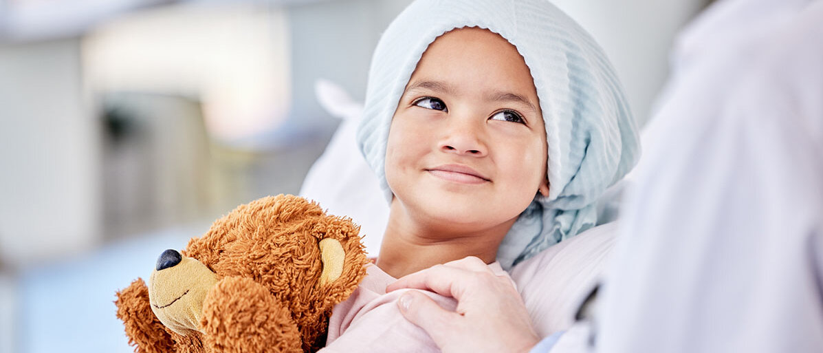 Kleines Mädchen im Krankenhaus mit einem Teddy in der Hand