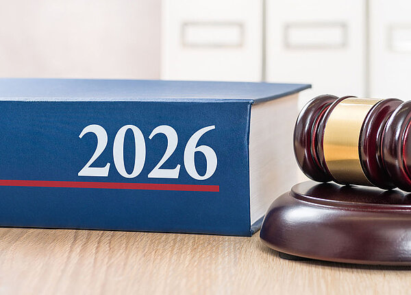 Buch mit 2026 auf dem Rücken, daneben Richterhammer