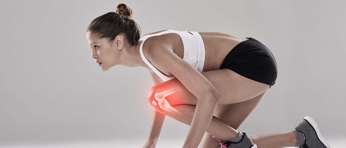 Eine Frau in Sportkleidung kniet in Startposition um loszurennen. In ihrem gebeugten Knie ist rot das Gelenk eingezeichnet.
