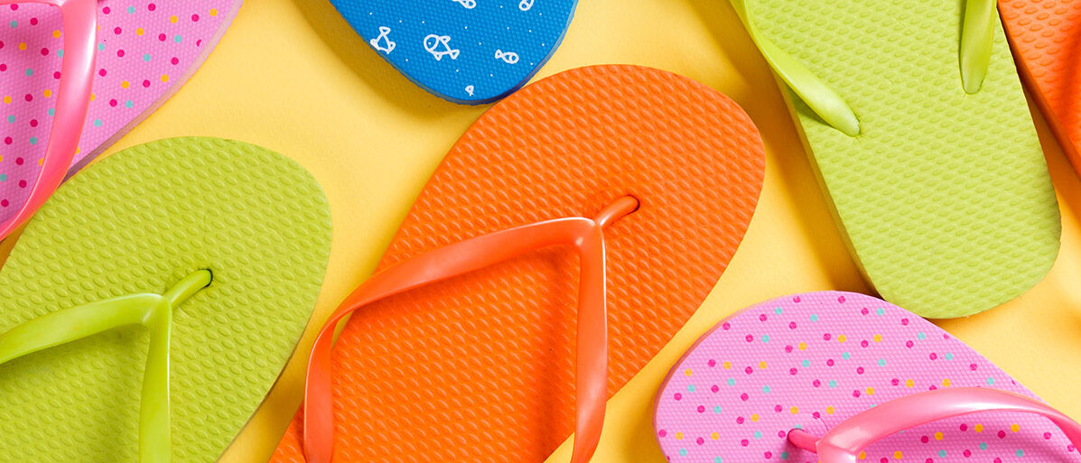 Flipflops Bunte Flipflops auf gelbem Hintergrund.