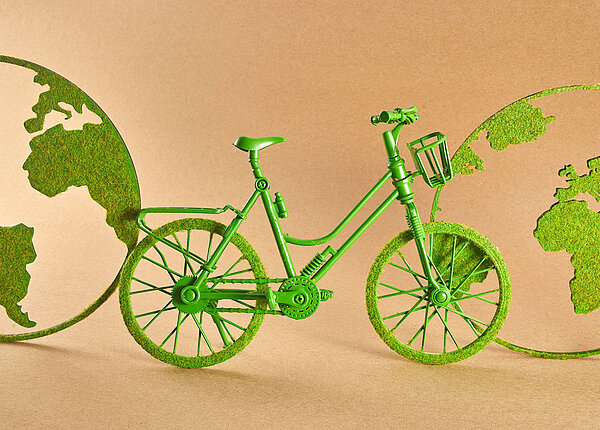 Grünes Fahrrad und Weltkugeln.