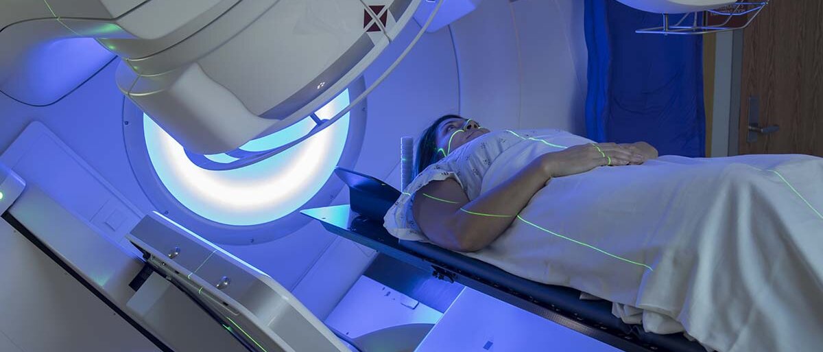 Eine Frau liegt auf einer Liege und wird in die Röhre zum CT geschoben