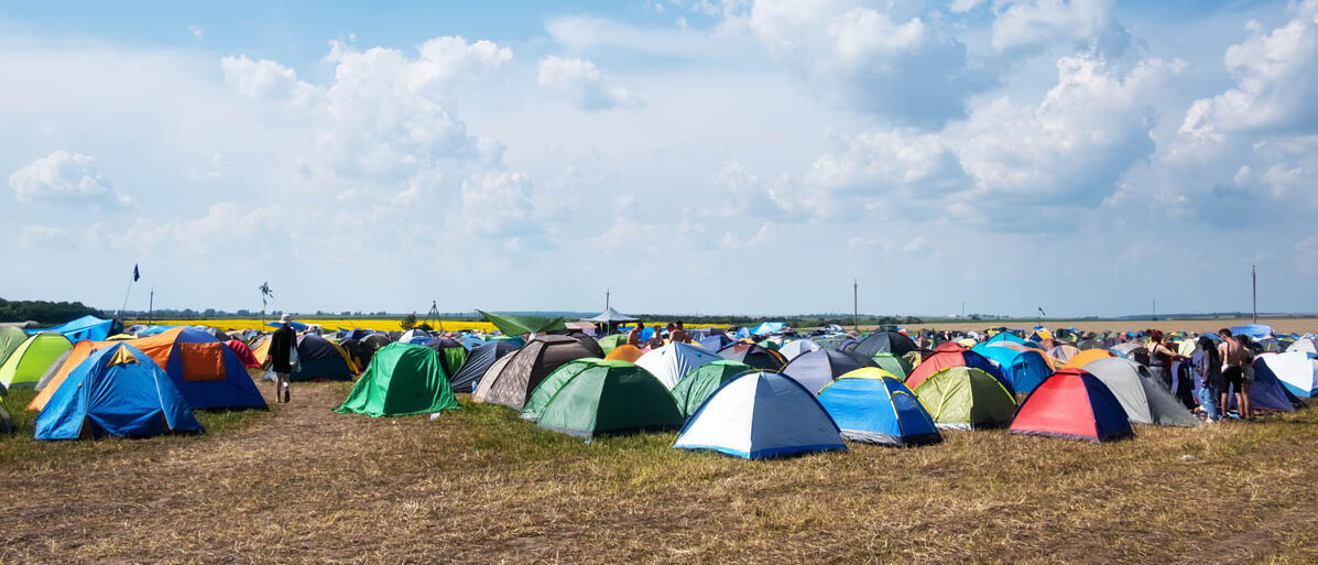 Essen auf dem Festival: Tipps für Snacks und Verpflegung und zum Umgang mit dem Campingkocher auf einem Festival Viele kleine Zelte auf einem Feld