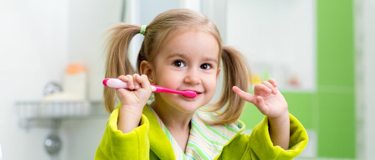 Ein kleines Mädchen, das sich die Zähne putzt.